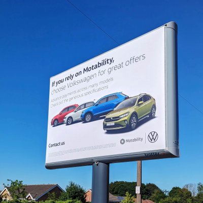 Large billboard sign for Volkswagon with cars on a white background. Poster reads 'if you rely on motability'