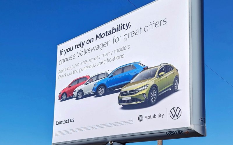 Large billboard sign for Volkswagon with cars on a white background. Poster reads 'if you rely on motability'