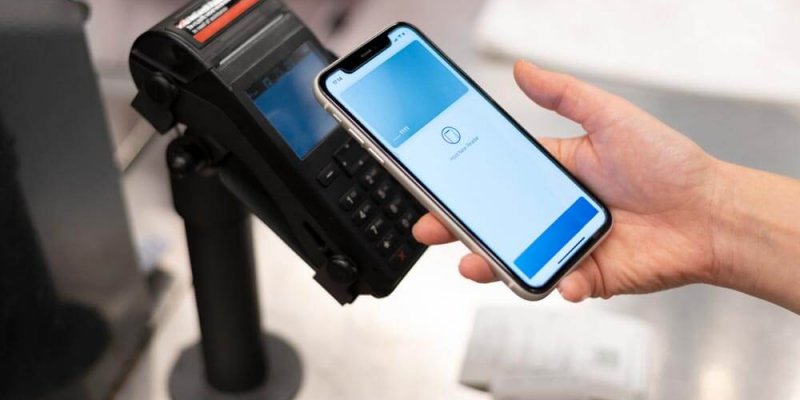 person paying for shopping via her phone using contactless payment