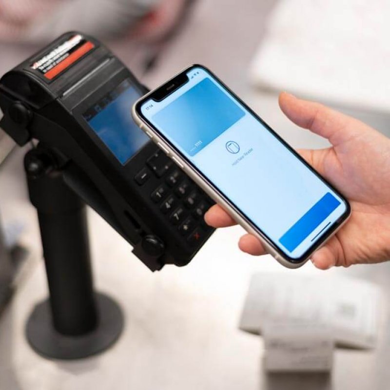 person paying for shopping via her phone using contactless payment