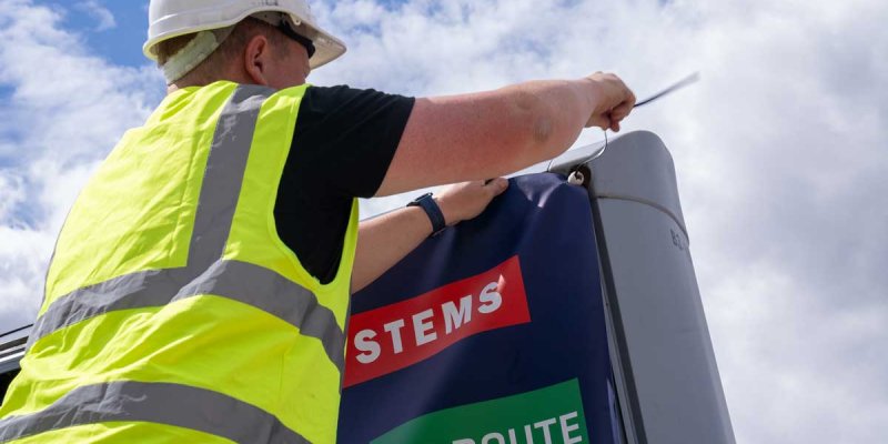 Trotter staff member replacing graphics on an outdoor billboard